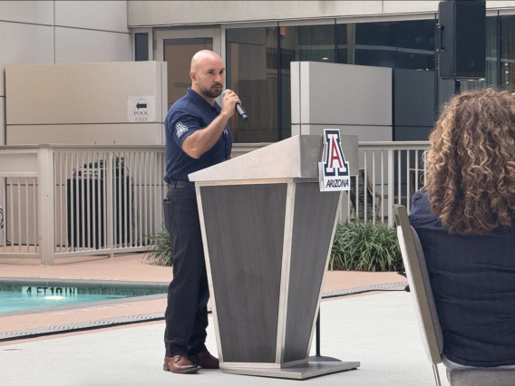 Carlos Vargas, assistant professor of astronomy, speaking at the Arizona Athletics Wildcat Club donor event in Houston, highlighting the University of Arizona's excellence in research and athletics.