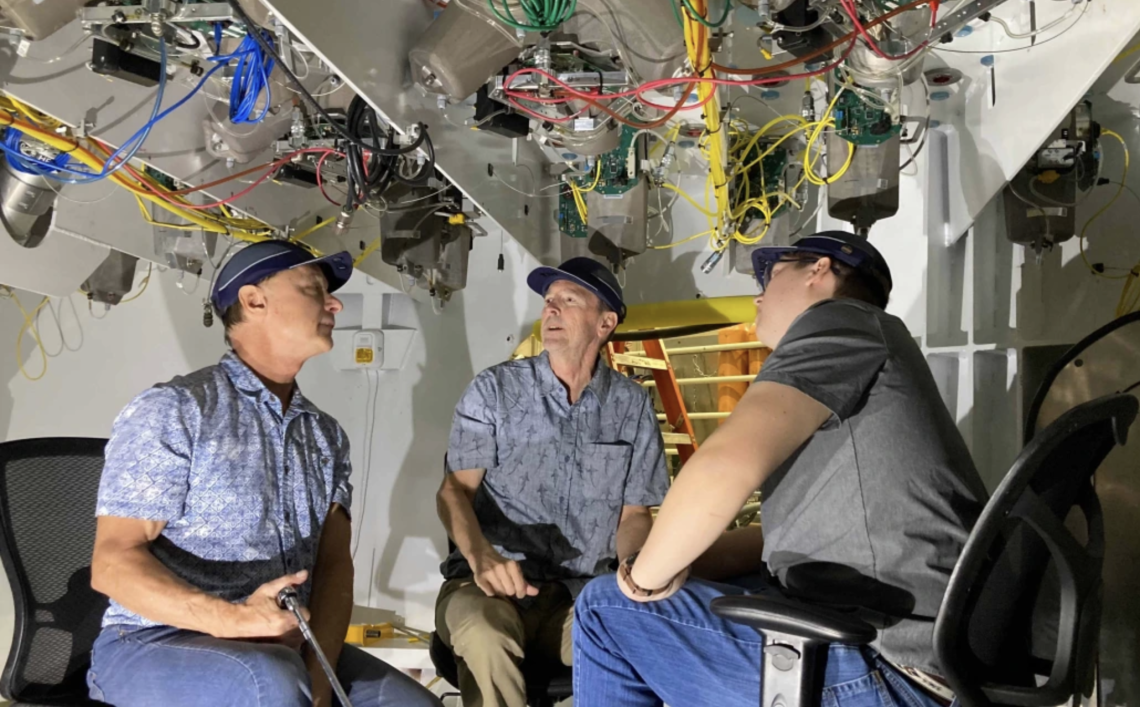 Buddy Martin (center) inspects components inside the support cell with Giant Magellan Telescope engineers Tomas Krasuski (left) and Colby Gottschalk (right).