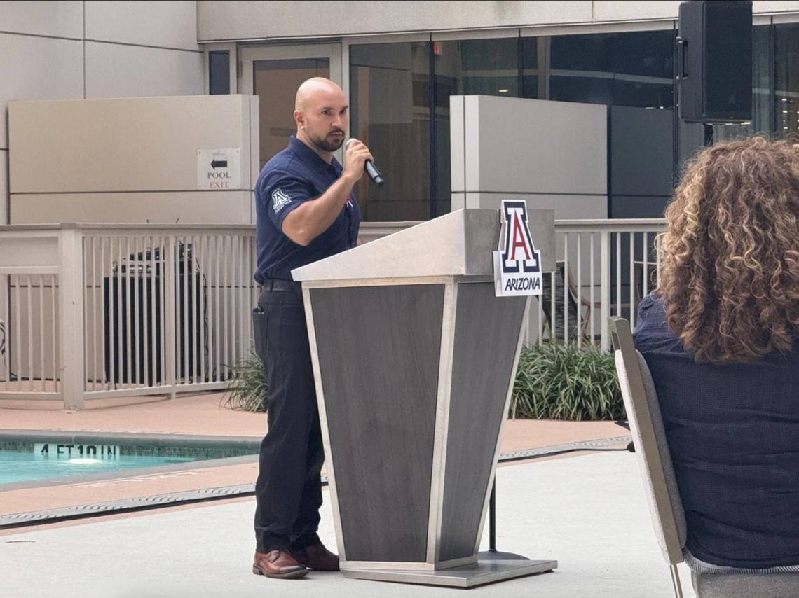 Carlos Vargas, assistant professor of astronomy, speaking at the Arizona Athletics Wildcat Club donor event in Houston, highlighting the University of Arizona's excellence in research and athletics.